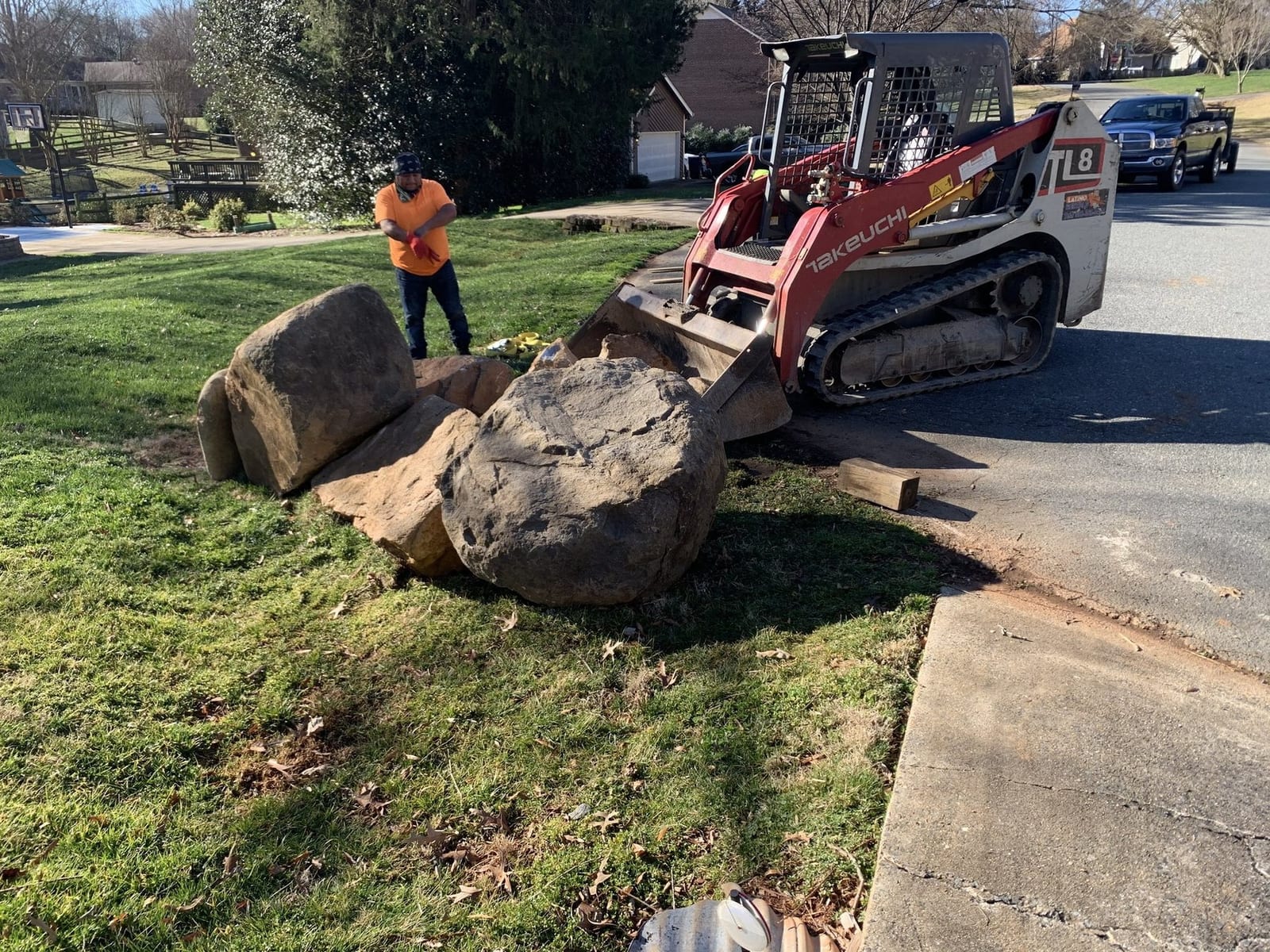 Track loader placing boulders on a job site