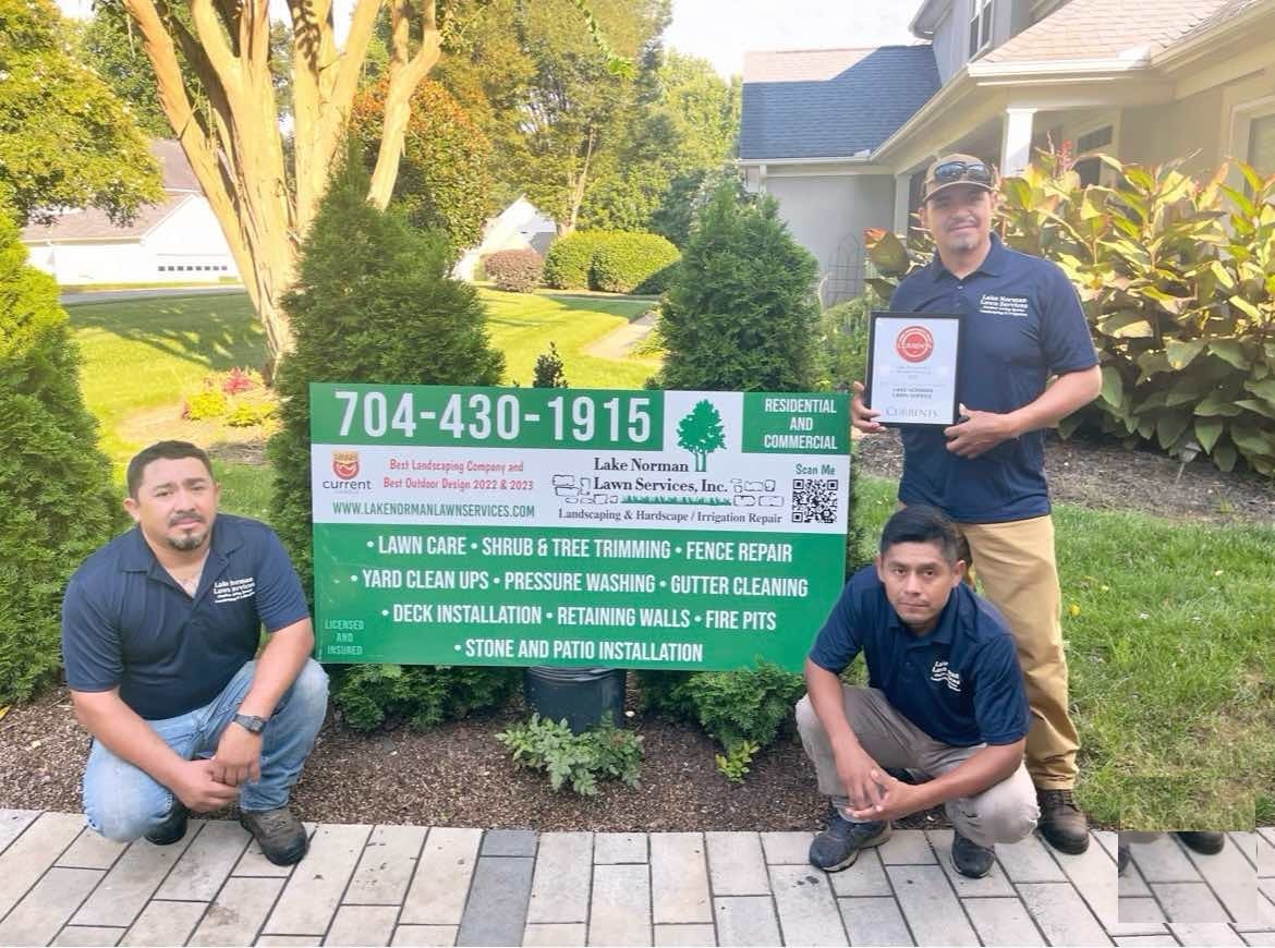 The Lake Norman Lawn Services crew beside the company sign