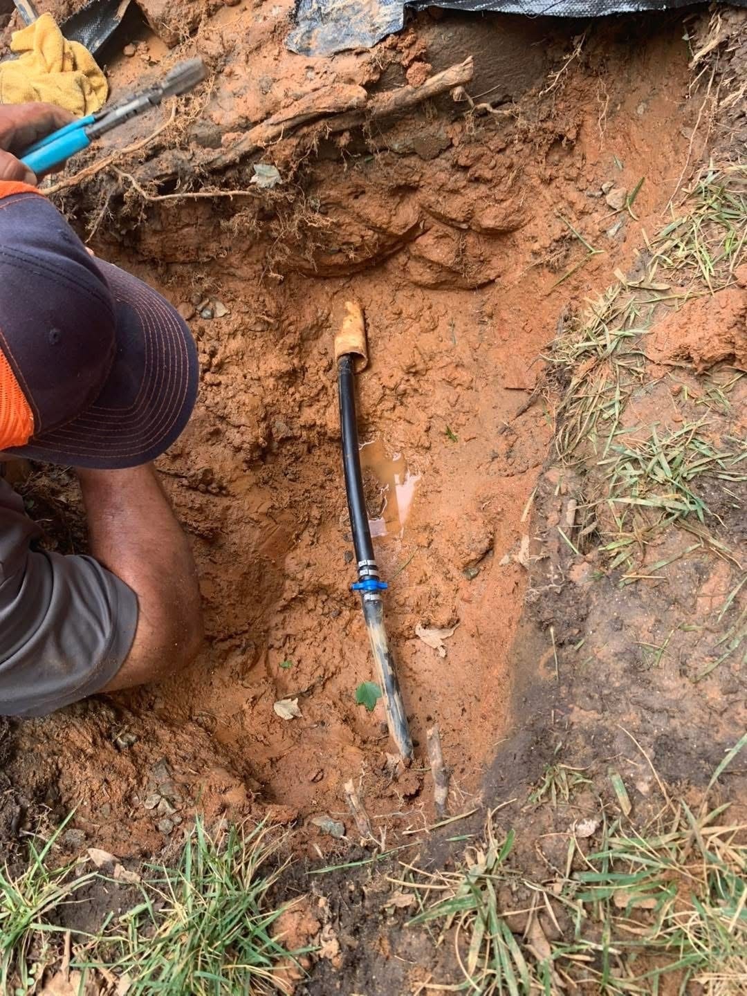 Crew member repairing a buried sprinkler line with a compression fitting