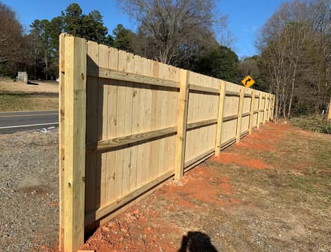 New wood privacy fence running along a road