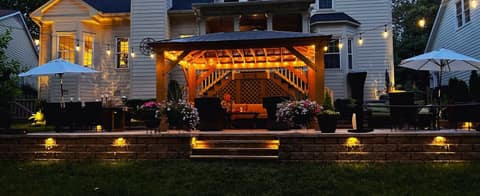 Backyard pergola and beds lit at dusk