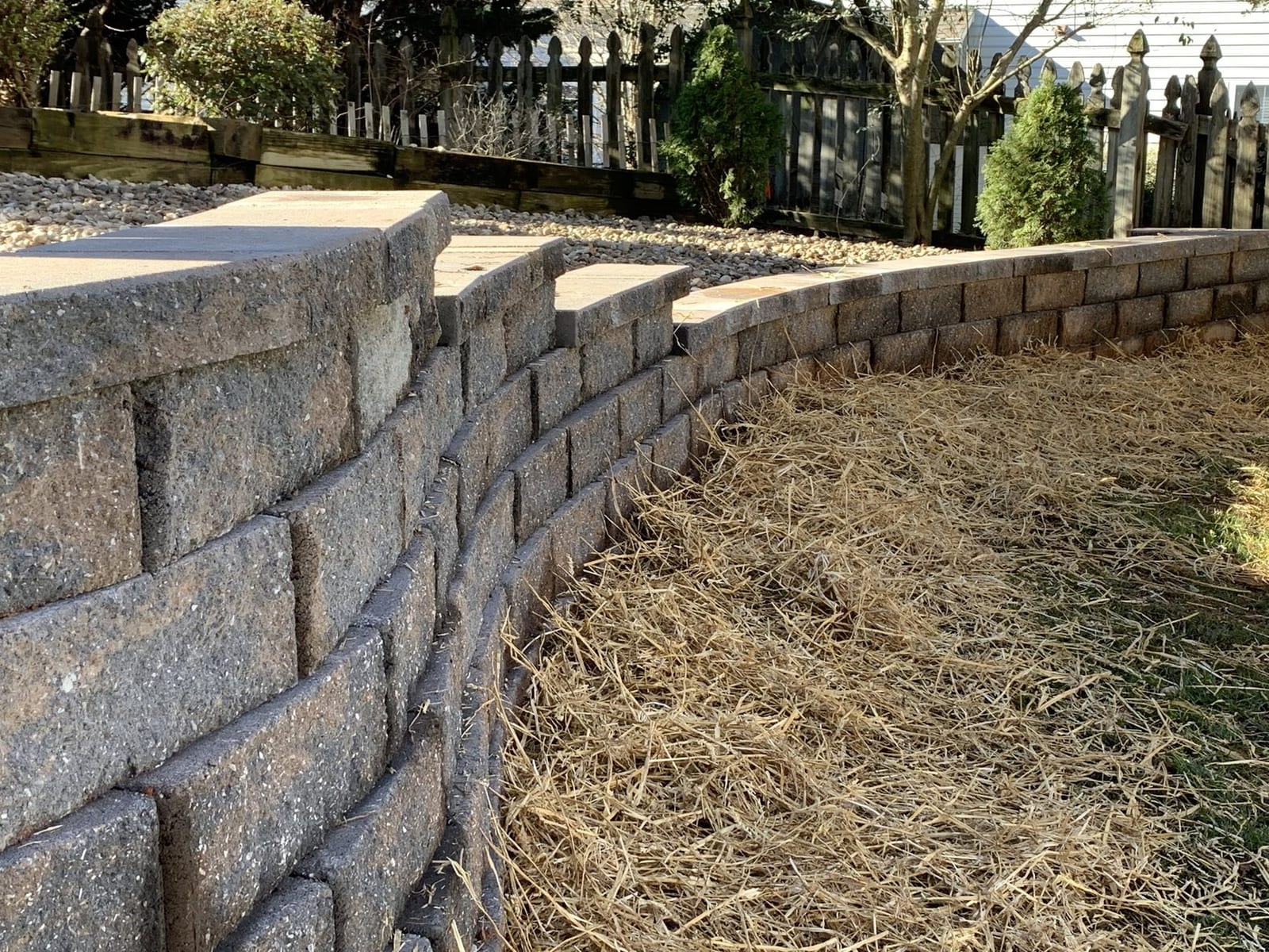 Curved block retaining wall with fresh planting above it