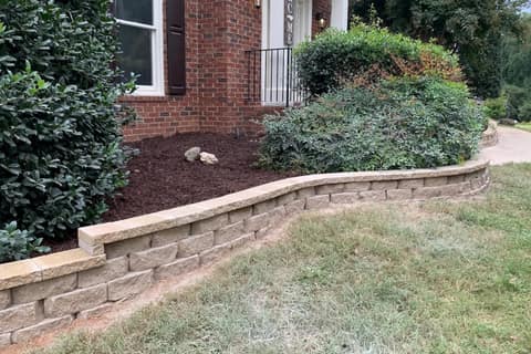 Low block wall raising a mulched front bed by a brick home